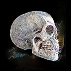 Digital artwork: Human skull with silver and orange patterns, flames, and smoke on black background