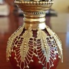 Amber-colored Glass Perfume Bottle with Faceted Cap on Gradient Background