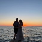 Silhouetted couple embracing at vibrant ocean sunset