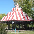 Whimsical Gazebo with Red & White Striped Roof in Lush Garden