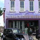 Vintage Black Car Parked in Front of Vibrant Purple Building