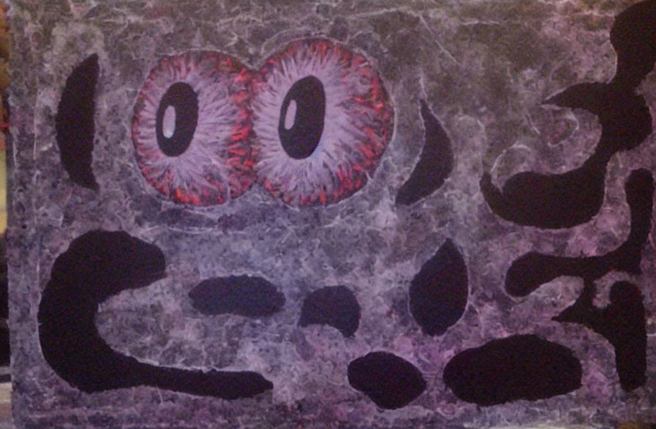 Large stylized eyes with red irises and abstract black patterns on a wall