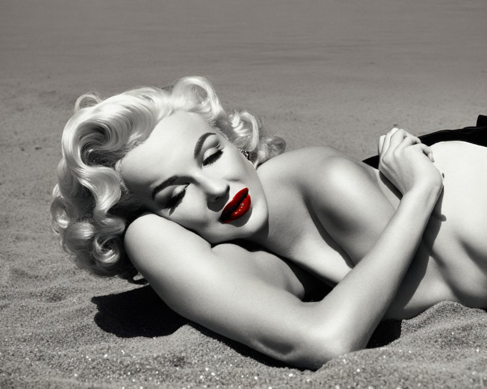Monochrome image: Woman with platinum blonde hair and red lipstick on sandy beach