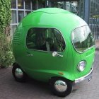 Green retro-futuristic vehicle in classic city setting.