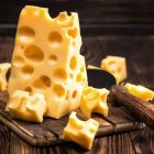 Assorted Swiss Cheese with Holes on Dark Wood Background