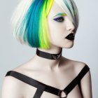 Vibrant multicolored hairstyle, bold makeup, choker, and silver pendant outfit