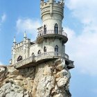 Whimsical castle with twin spires on rocky cliff by the sea