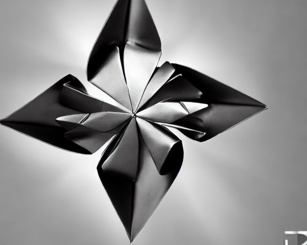Origami black flower on gray gradient with shadows