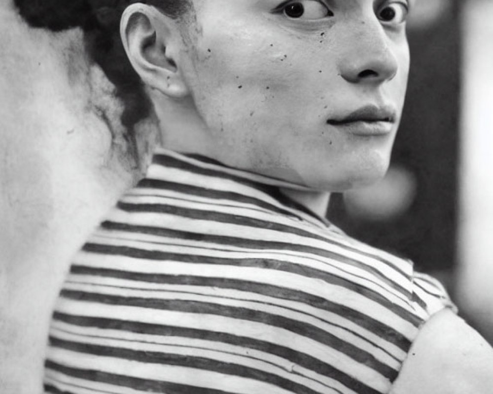 Monochrome portrait of young person with braided hair in striped shirt
