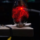 Red Plasma Glow Filament in Glass Bell Jar on Dark Background