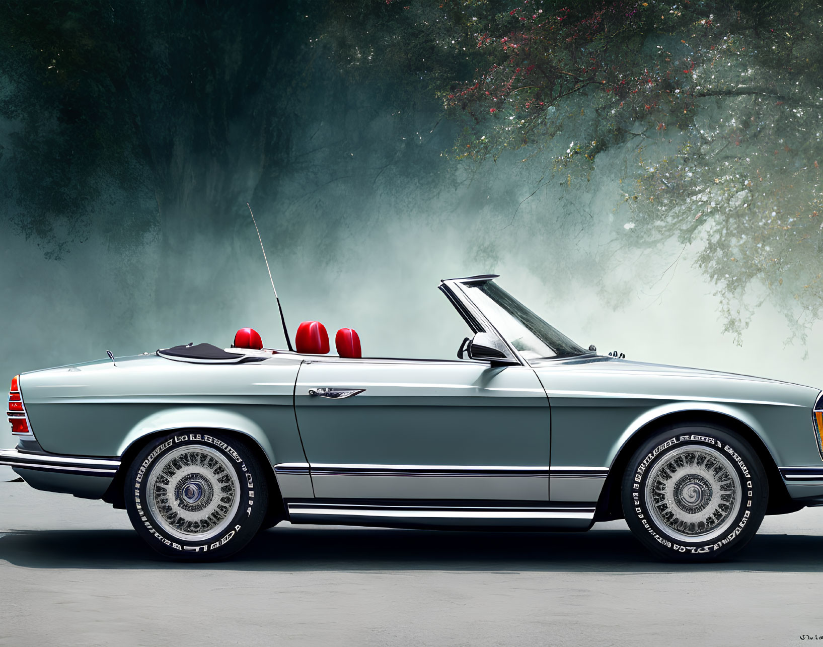 Vintage Convertible Car with Chrome Details and White-Wall Tires Parked Against Misty Trees