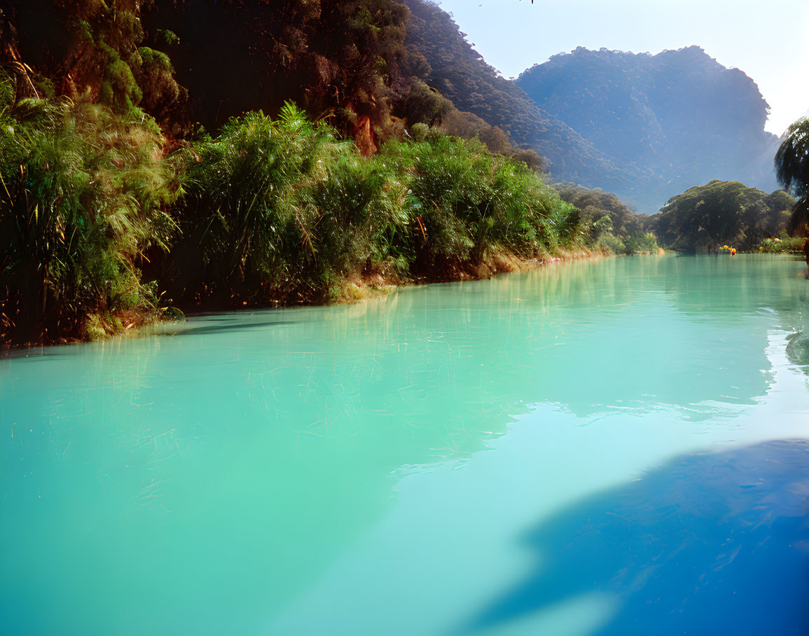 Tranquil Turquoise River with Greenery and Mountains
