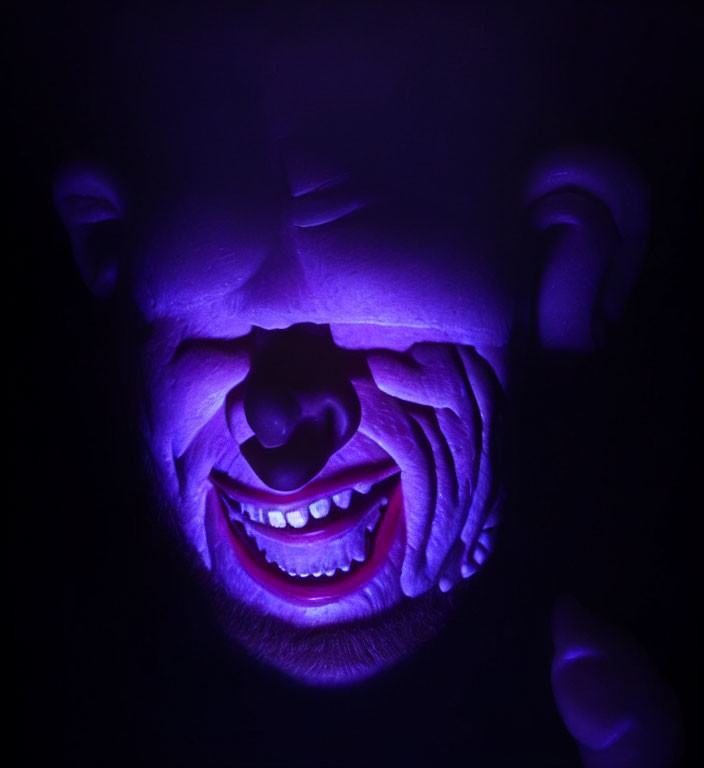 Creepy smiling purple mask under ultraviolet light