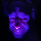 Fantastical Creature with Purple Skin and Red Eyes Under UV Light