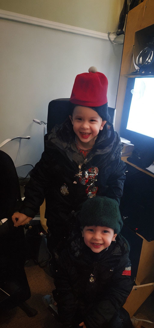 Smiling children in colorful hats and jackets indoors