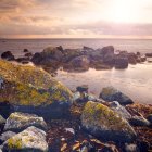 Tranquil Sunset Seascape with Waves and Rocky Shore