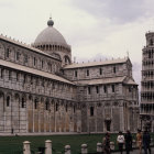 Historic complex with cathedral, baptistery, and leaning tower in scenic setting