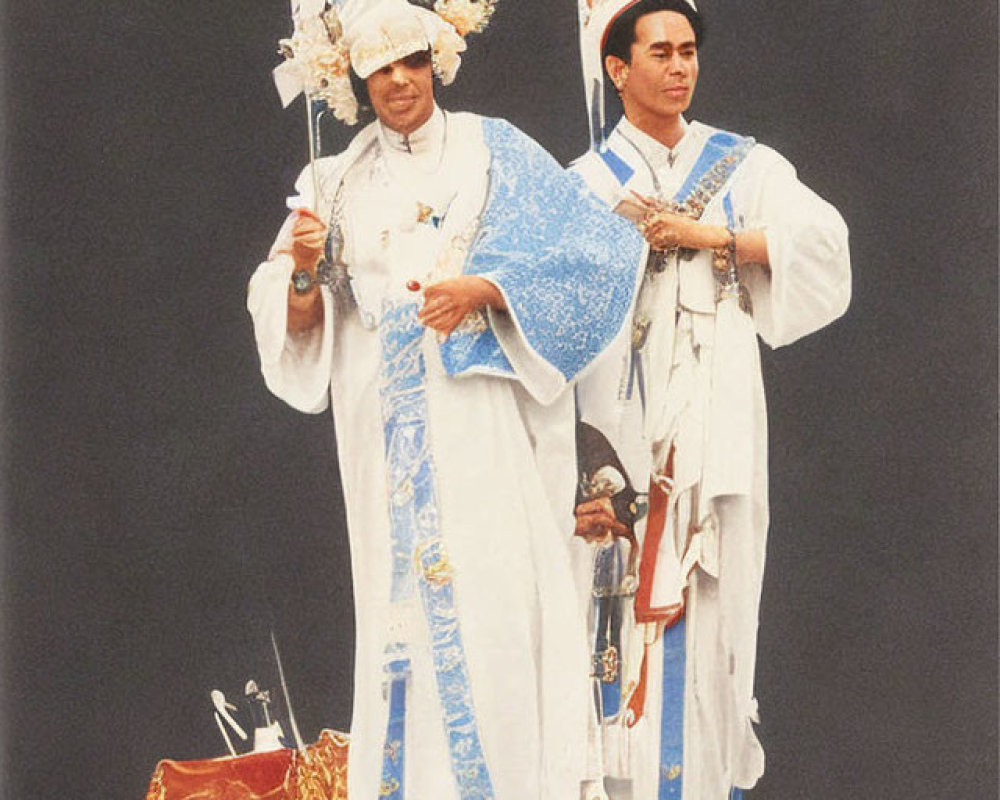 Elaborate White Costumes with Pointed Hats and Thai Text Backdrop