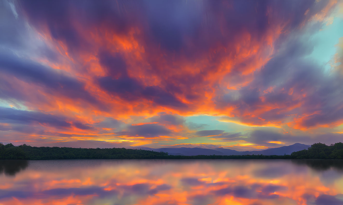 Scenic sunset with fiery clouds reflected on tranquil lake