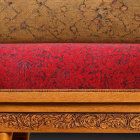Ornate wooden chair with red cushion and carved design