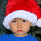 Child with Blue Eyes in Santa Hat and Festive Attire Against Twinkling Background