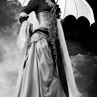 Vintage-style black and white photo of elegant model in ornate gown with lace parasol