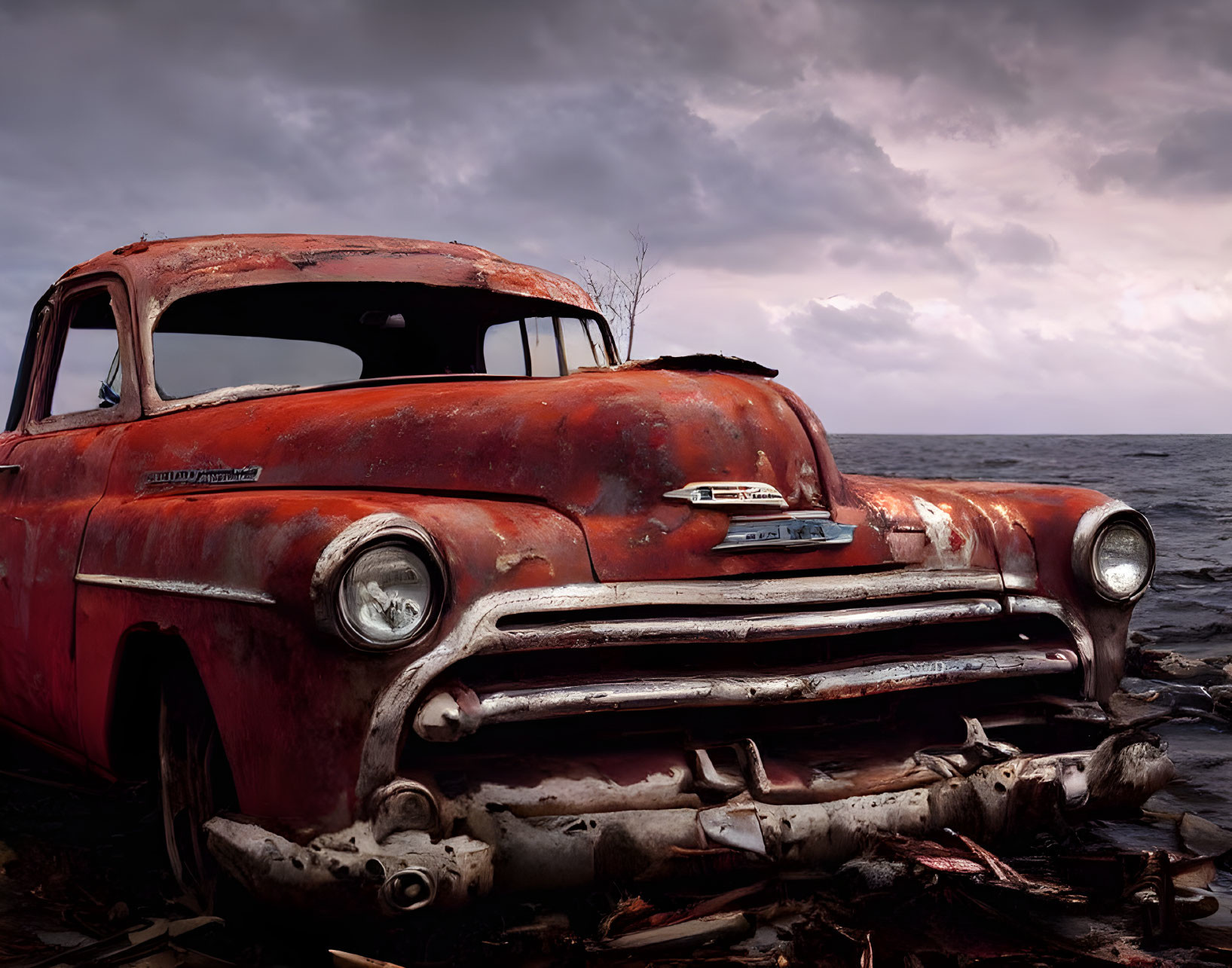 Rusty Chevrolet pickup truck by stormy sea with faded red paint
