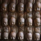 Identical fetus sculptures in gestational poses on dark background