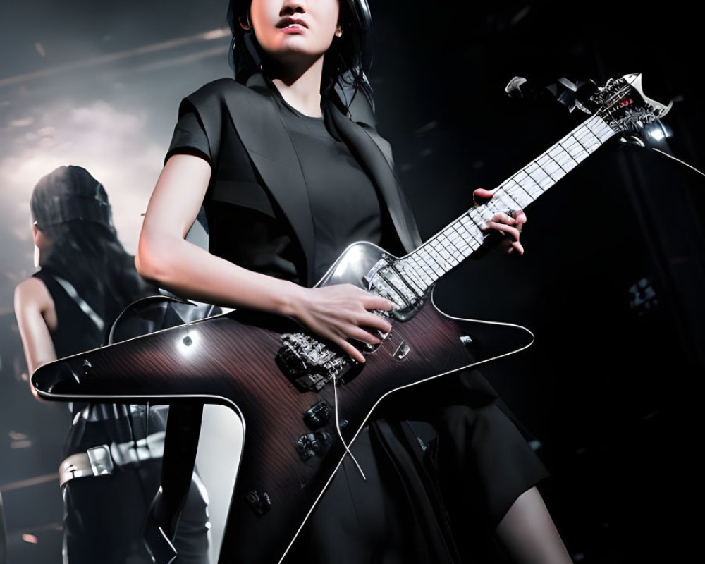 Woman Performs with Black Guitar on Stage in Spotlight