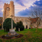 Whimsical storybook-style church with manicured topiary under dramatic sky