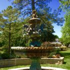 Colorful painting of elaborate fountain in lush garden