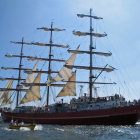 Tall ship with full sails navigating stormy sea