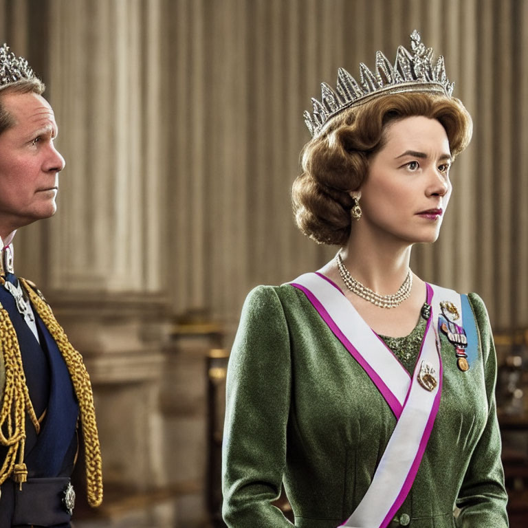 Regal man and woman in crowns and sashes with serious expressions