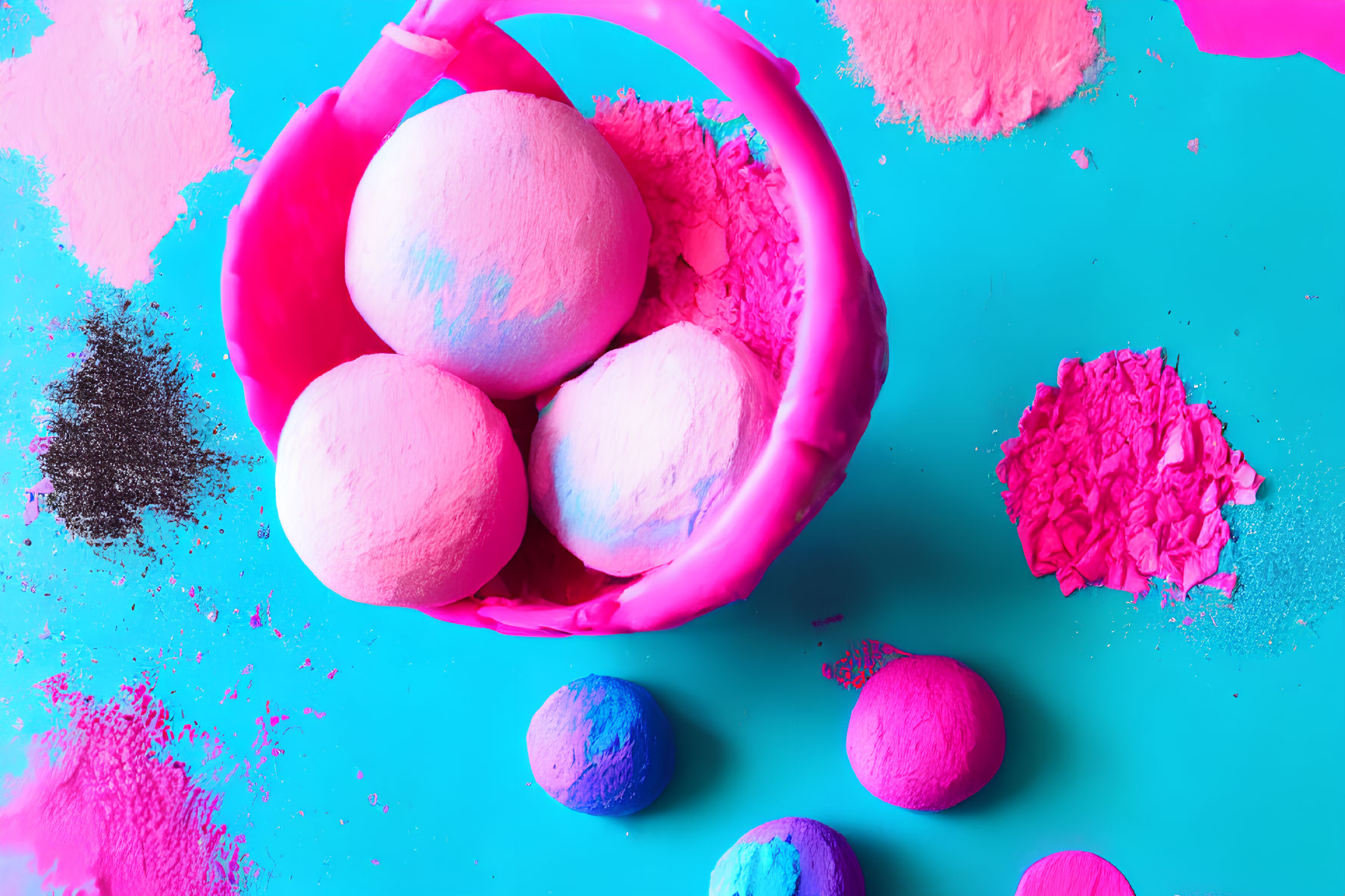Colorful bath bombs in pink basket on blue background with powdery pigments