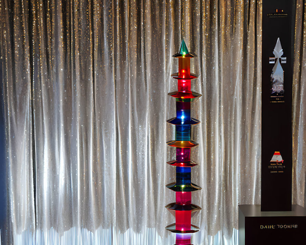 Colorful Glass Sculpture on Silver Curtain Backdrop with Red Floor and Information Stand
