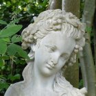 Sculptural woman's face with butterflies in verdant setting