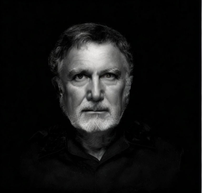 Monochrome portrait of older man with beard and intense gaze