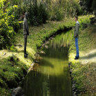 Two people near water and greenery in contemplative poses