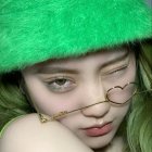 Striking Green-Eyed Person in Vibrant Makeup and Sparkling Cap