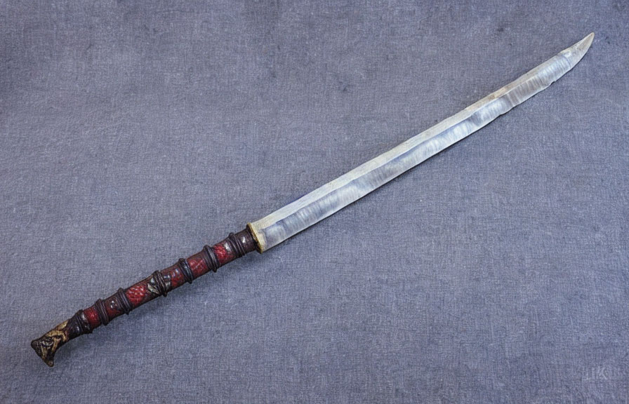 Patterned Blade Antique Sword with Leather-Wrapped Hilt on Grey Background