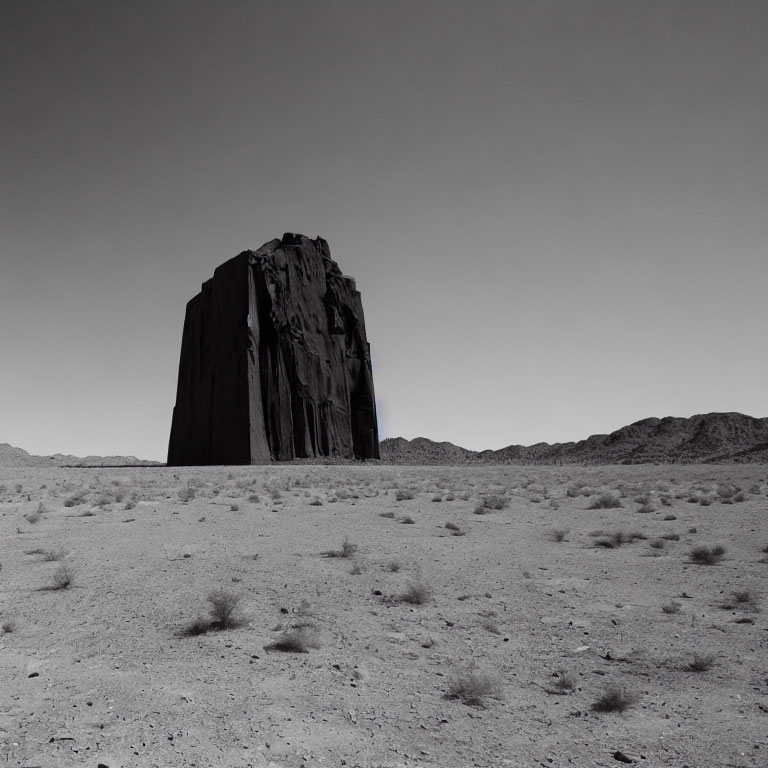 Prominent Monolithic Rock Formation in Barren Desert Landscape