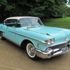 Vintage Light Blue Convertible Car with Chrome Details on Sandy Ground