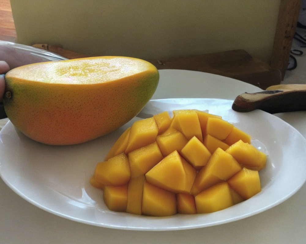 Fresh sliced mango on white plate with wooden table background