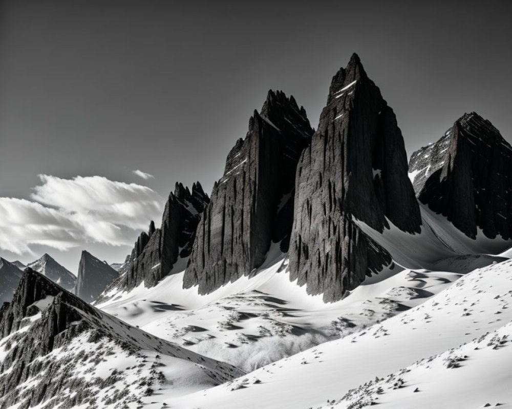 Snow-covered jagged mountain peaks in dramatic black and white tones