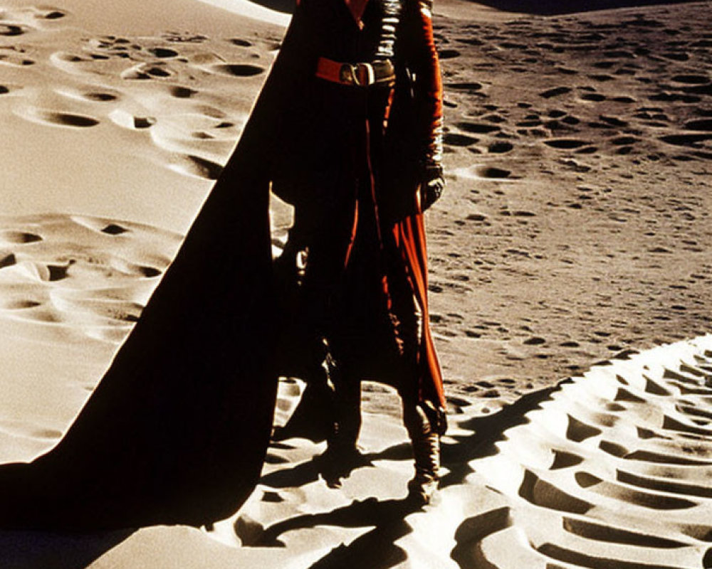 Person in Red and Black Outfit on Rippled Sand Dunes under Blue Sky