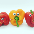 Three Bell Peppers in Red, Yellow, and Green on Light Blue Background