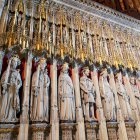 Ornate Fantasy Swords Displayed Above Robed Character Statues