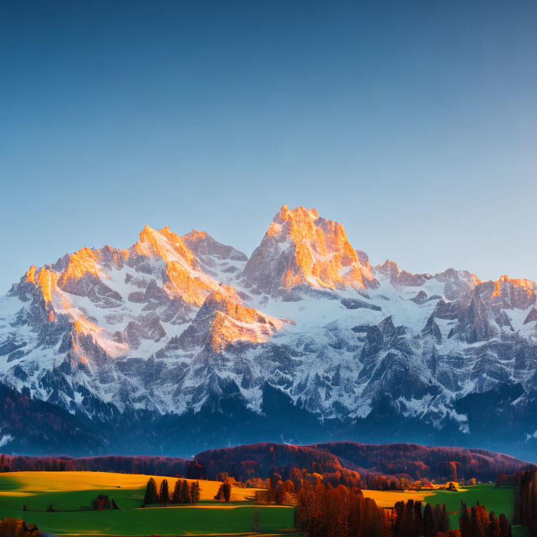 Snow-capped mountains at sunrise over lush green valley