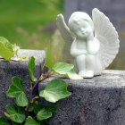 Translucent-winged fairy figurine on rock in lush greenery