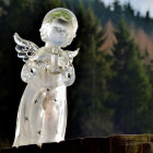 Porcelain fairy statue by miniature stream with colorful orbs and butterflies